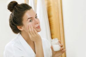 Woman putting coconut oil on her face