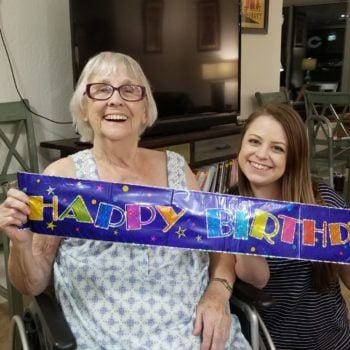 Grandma and Emily with a Happy Birthday sign