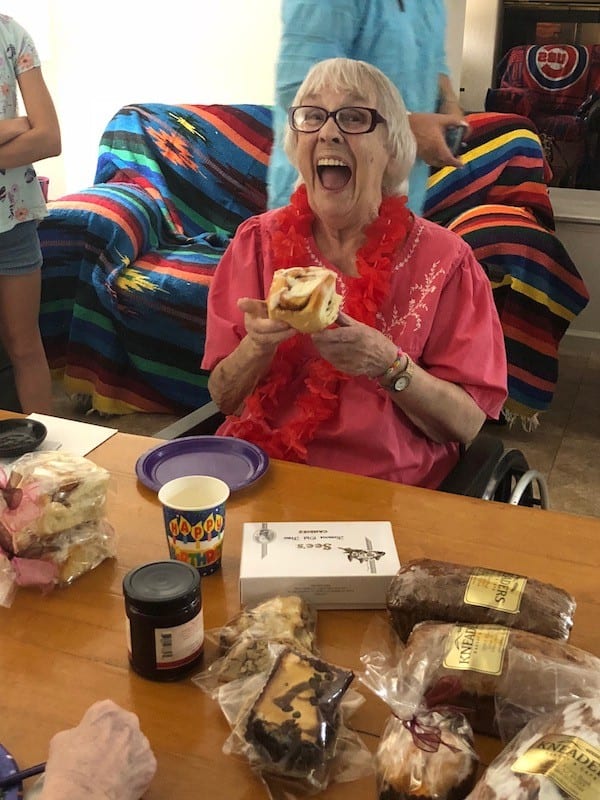 Grandma taking a big bite of cinnamon roll